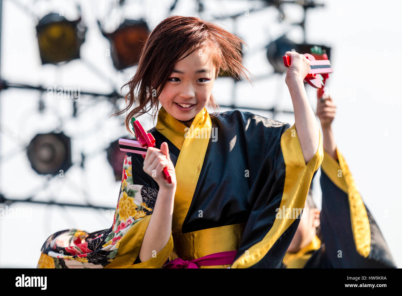 Festival Danse Yosakoi Hinokuni. Enfant souriant, girl, danse en noir et jaune yukata, holding naruko, danse. Close-up, en souriant. Banque D'Images