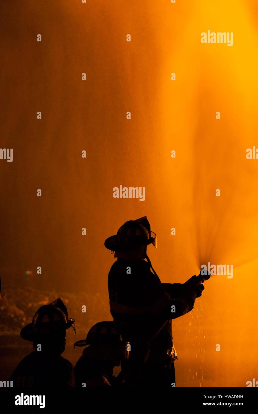 United States, Massachusetts, Cape Ann, Rockport, quatrième de juillet Bonfire, silhouettes de pompiers Banque D'Images