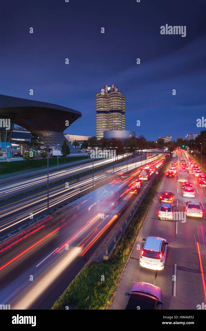 Germany, Bavaria, Munich, BMW Welt showroom de l'entreprise, siège de l'entreprise BMW et BMW Museum avec trafic du soir Banque D'Images