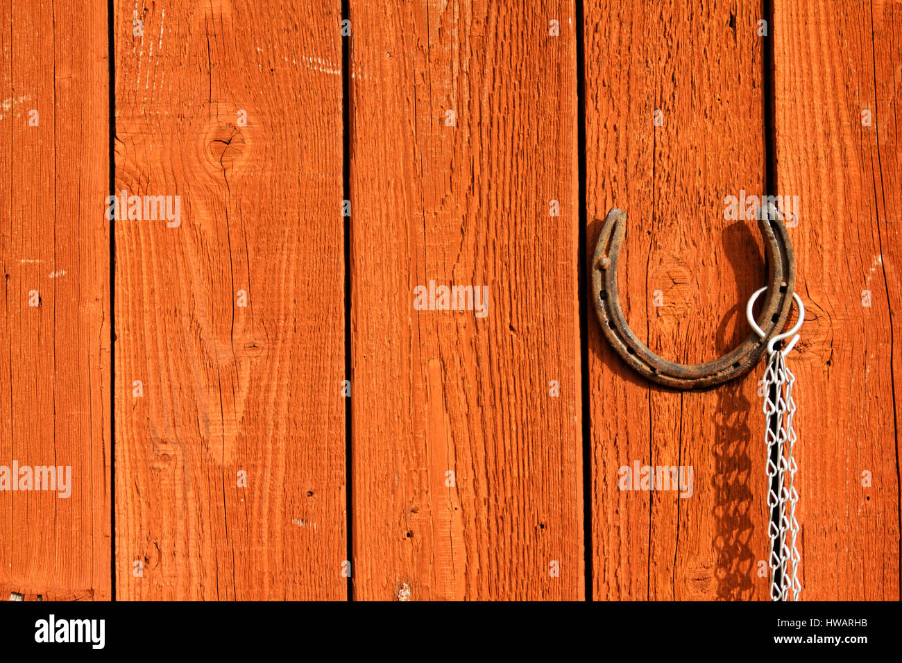 Old rusty horseshoe suspendu par une porte en bois brun Banque D'Images