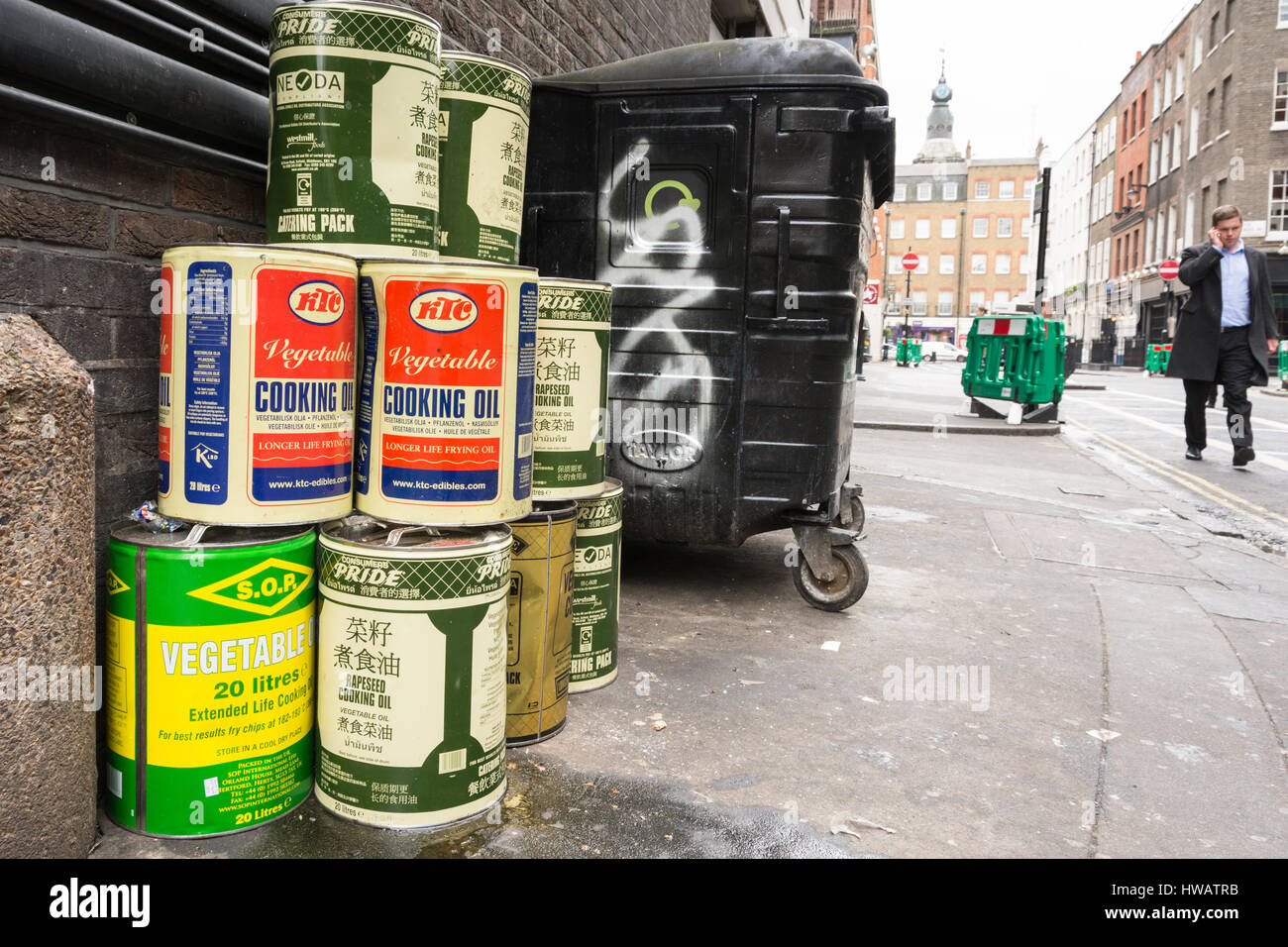 Fuite et vidage de fûts d'huile de cuisson végétale sur un trottoir à Soho, centre de Londres, Angleterre, Royaume-Uni Banque D'Images