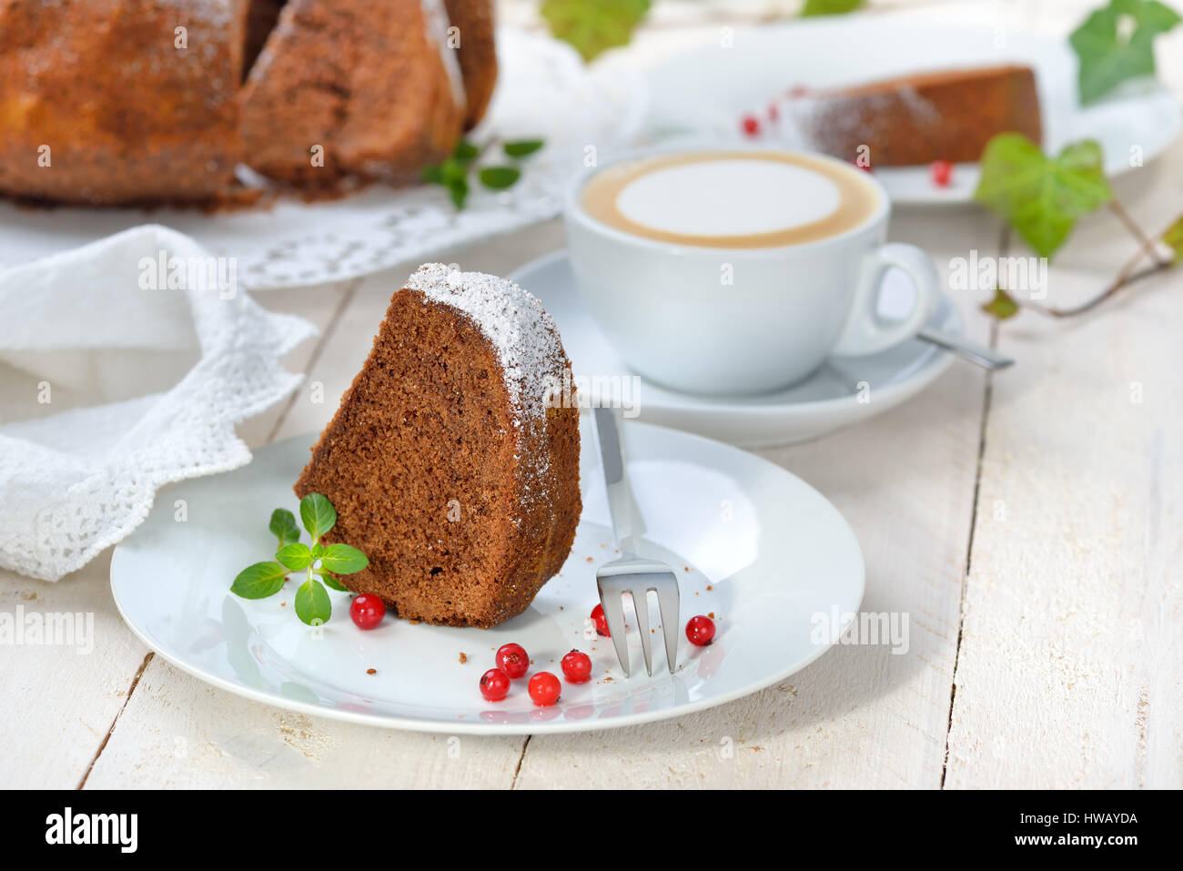 Du gâteau en forme de bague avec du chocolat, des 'Gugelhupf" en Autriche et Allemagne, servi avec une tasse de cappuccino Banque D'Images