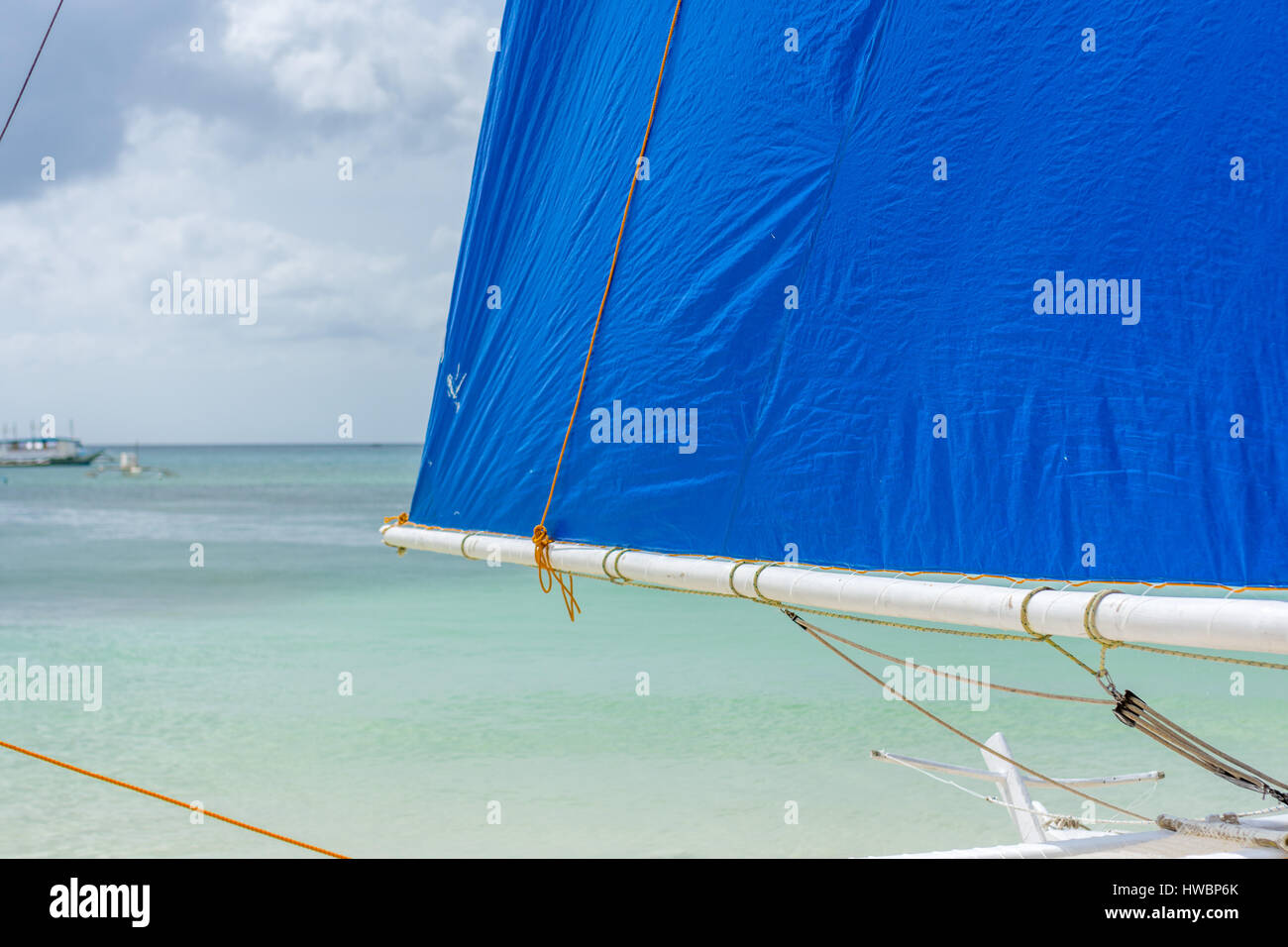 L'accent Premier plan d'un bateau à voile Philippines Philippines sur la plage donnant sur une mer calme avec des bateaux de la pompe à l'arrière du terrain. Banque D'Images