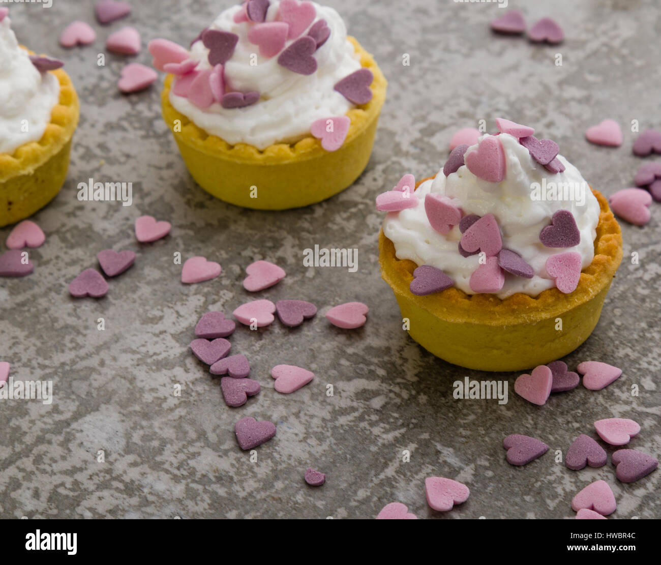 Mini tarte avec crème fouettée et ornement coeur rose Banque D'Images