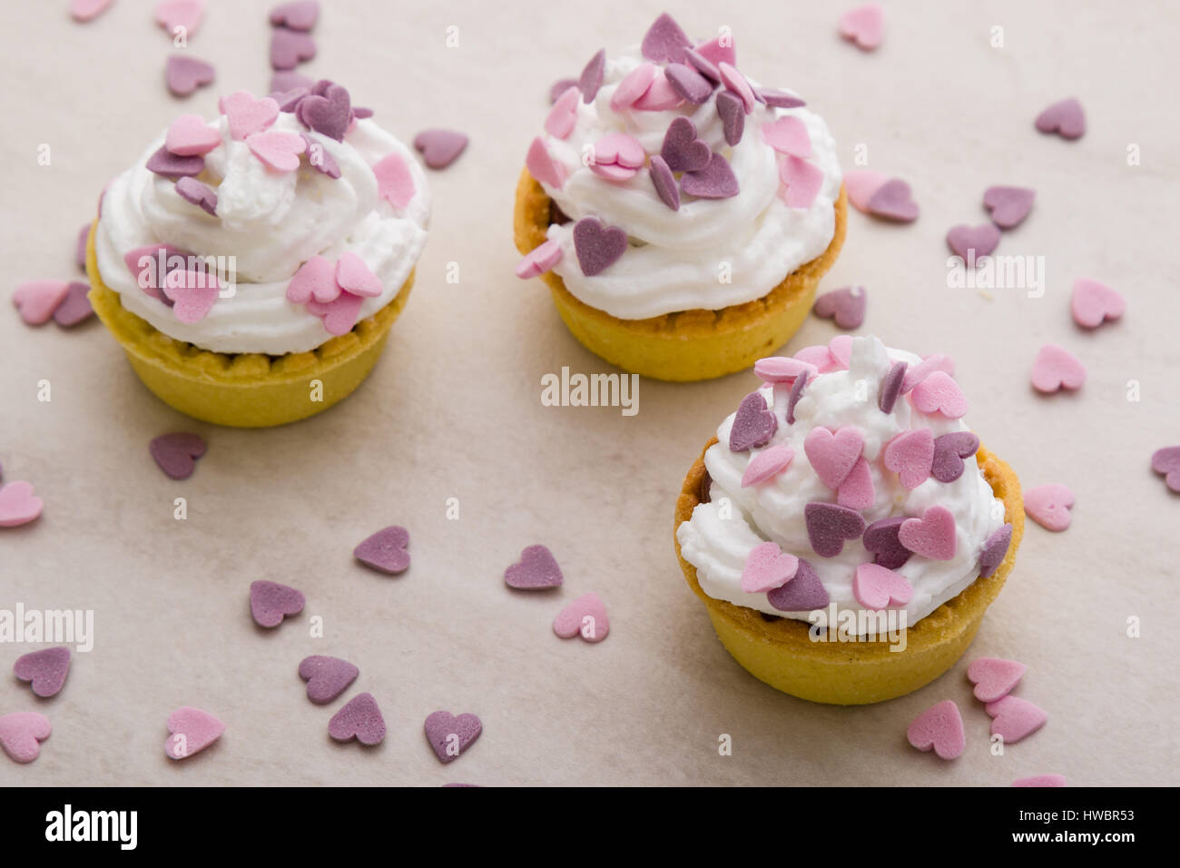 Mini tarte avec crème fouettée et ornement coeur rose Banque D'Images