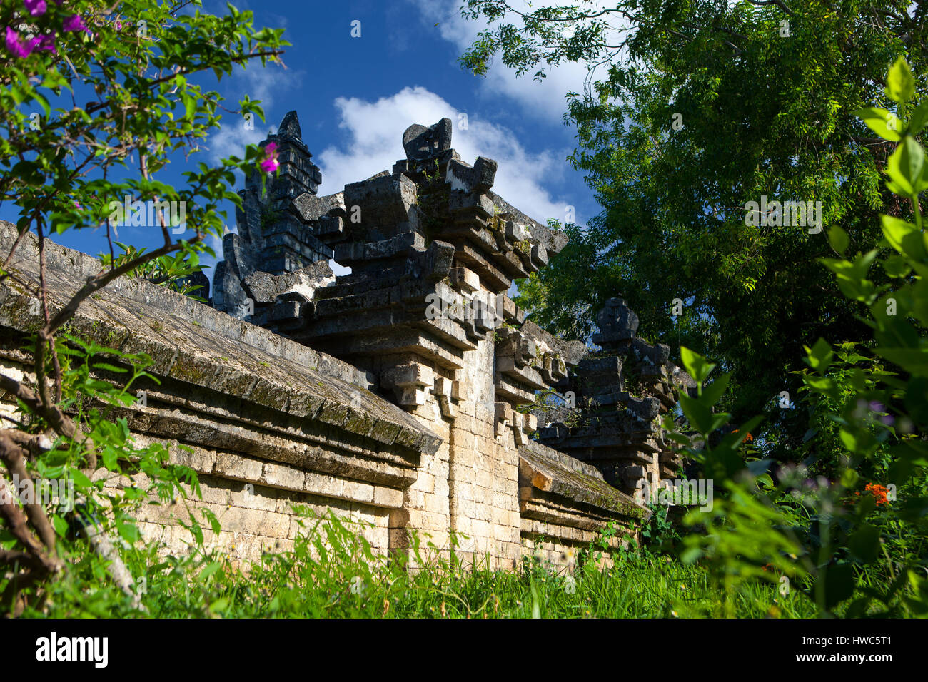 Ancien mur de briques d'un temple balinais parmi la verdure sur une journée ensoleillée, l'Indonésie Uluwatu Banque D'Images