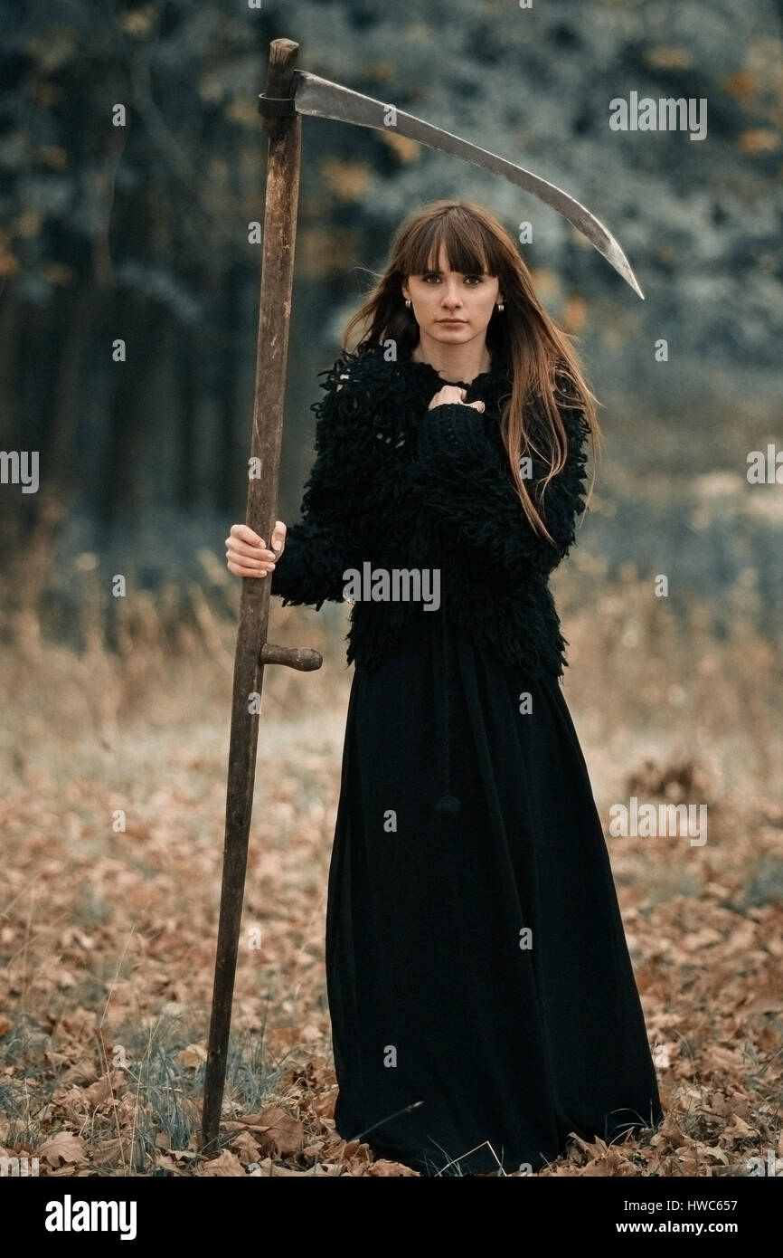 Photo gros plan de très sérieuses belle jeune fille avec de longs cheveux de noir avec braid sur forêt sombre arrière-plan. Fille mystique grave avec seri Banque D'Images