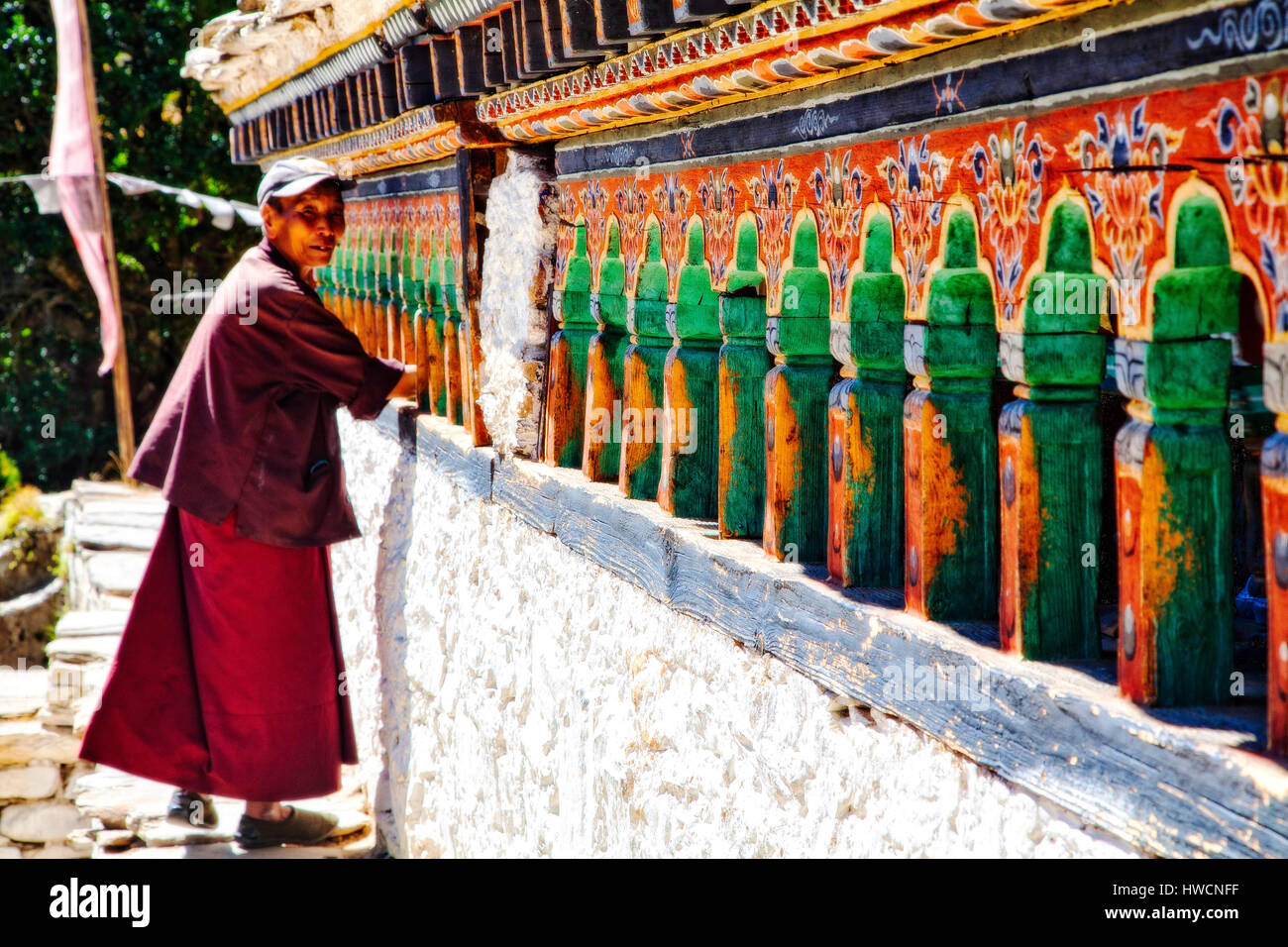 Une femme travaille les roues de prière à l'Rimochen Tang Le Monastère Lhakhang, Bhoutan Banque D'Images