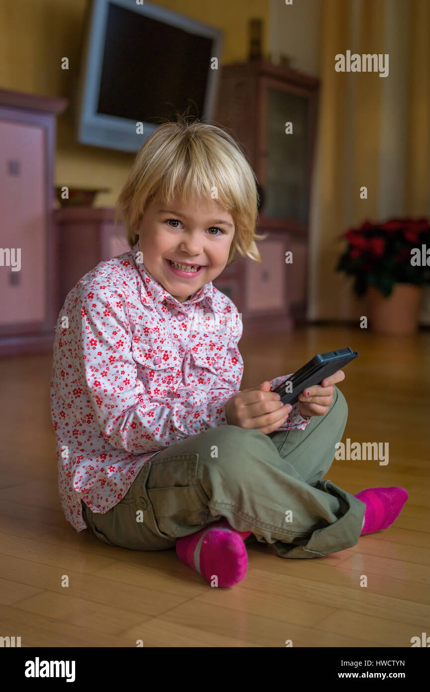 Un enfant joue avec un téléphone mobile. Téléphone mobile pour enfants, Ein genre spielt mit la main. Mobiltelefon für Kinder Banque D'Images