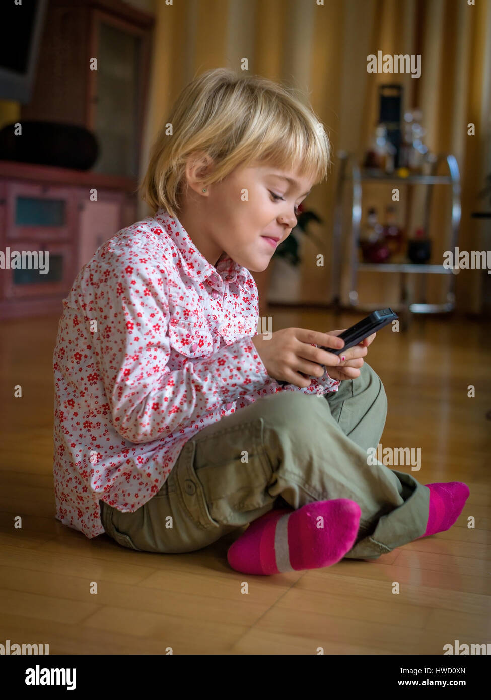 Un enfant joue avec un téléphone mobile. Téléphone mobile pour enfants, Ein genre spielt mit la main. Mobiltelefon für Kinder Banque D'Images