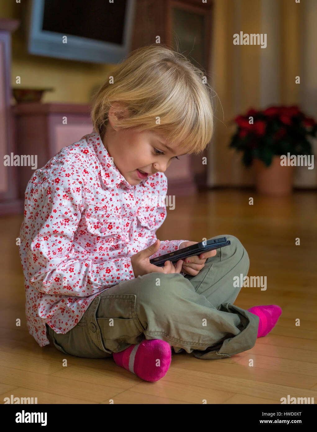Un enfant joue avec un téléphone mobile. Téléphone mobile pour enfants, Ein genre spielt mit la main. Mobiltelefon für Kinder Banque D'Images