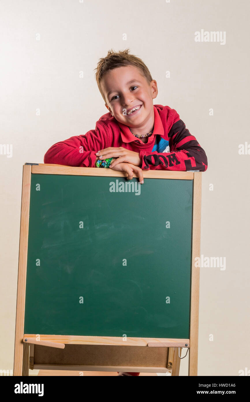 Un enfant avec un conseil scolaire. , Ein Genre mit einer leeren Schultafel. Banque D'Images