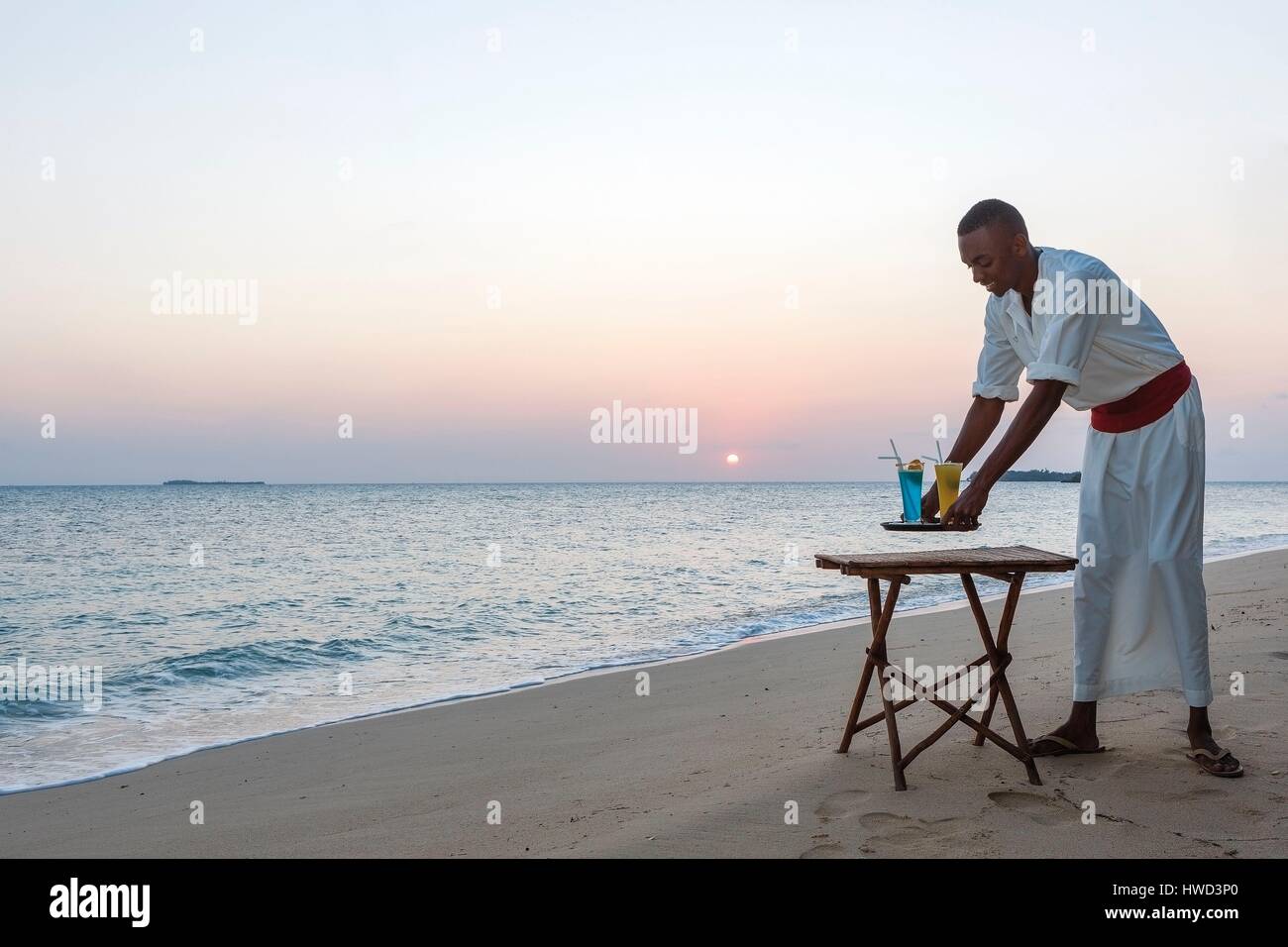 La Tanzanie, Zanzibar, Chapwani, Chapwani Private Island Resort, le serveur  d'un hôtel de luxe avec un cocktail de bienvenue sur la plage Photo Stock -  Alamy