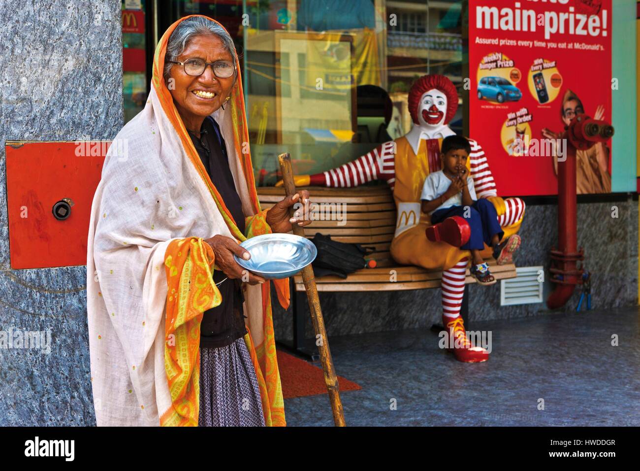 L'Inde, le territoire de la capitale nationale de Delhi, Old-Delhi, mendiant devant un enseigne Macdonald Banque D'Images