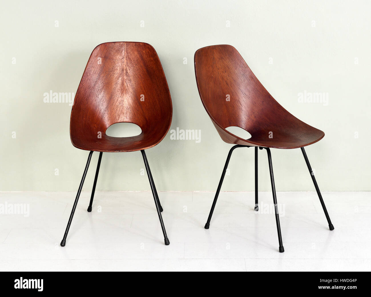 De Meubles anciens Paire de chaises en bois rond rétro noir avec pattes de métal dans la pièce avec un fond blanc et marbre Banque D'Images