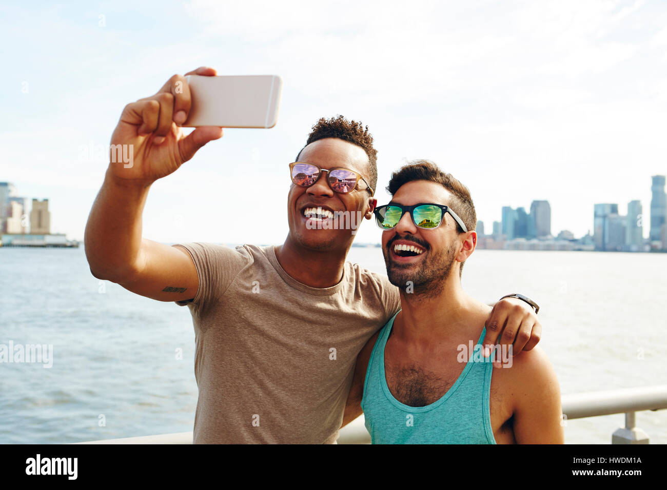 Deux jeunes hommes en tenant sur le bord de selfies smartphone, New York, USA Banque D'Images