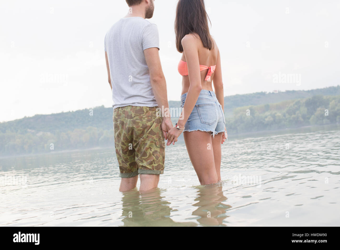 Couple holding hands par river Banque D'Images