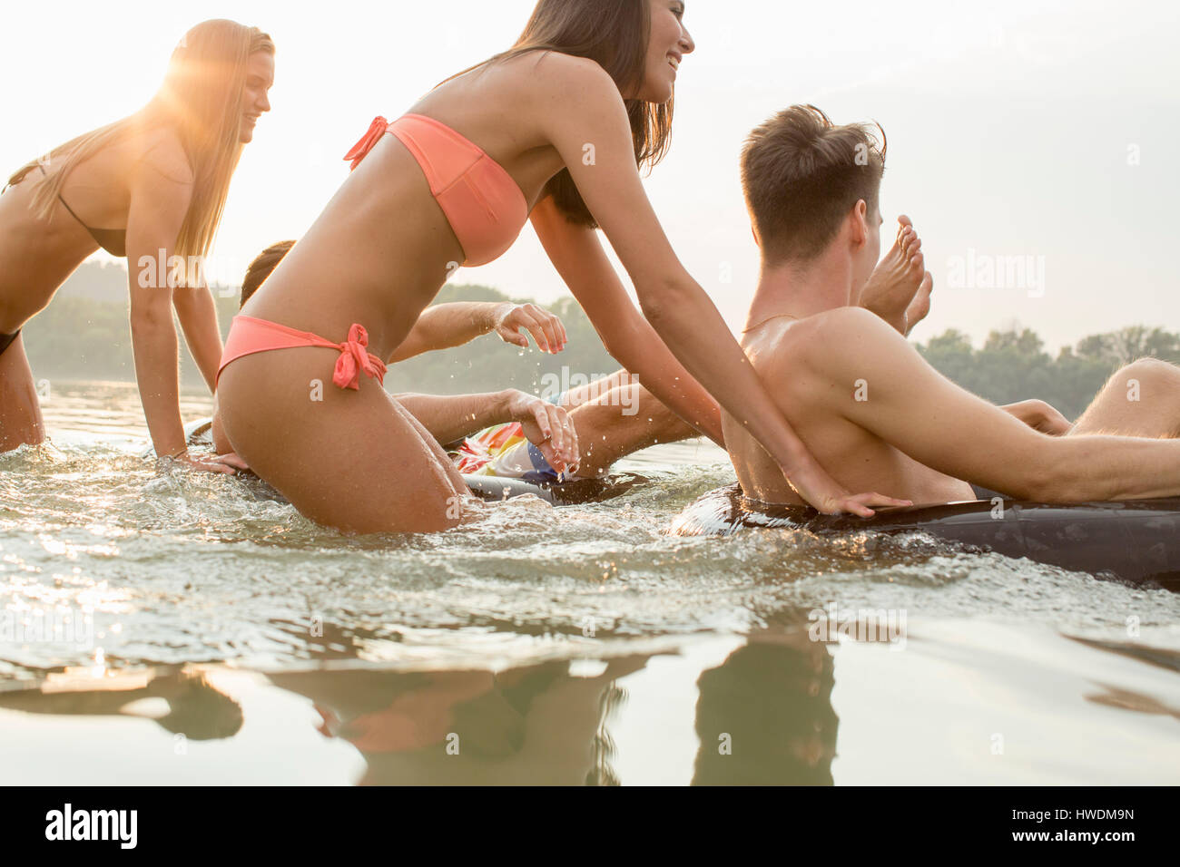 Les amis s'amusant avec anneau gonflable dans river Banque D'Images