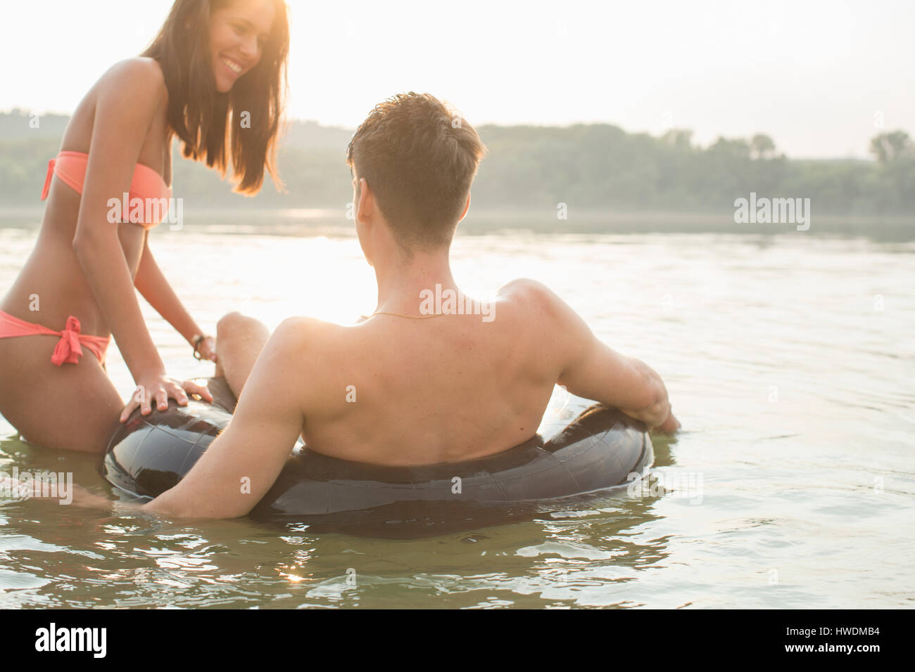 Les amis s'amusant avec anneau gonflable dans river Banque D'Images