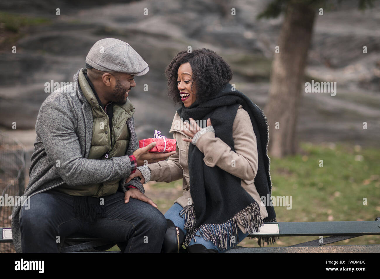 Homme romantique remise petite amie un cadeau en park Banque D'Images