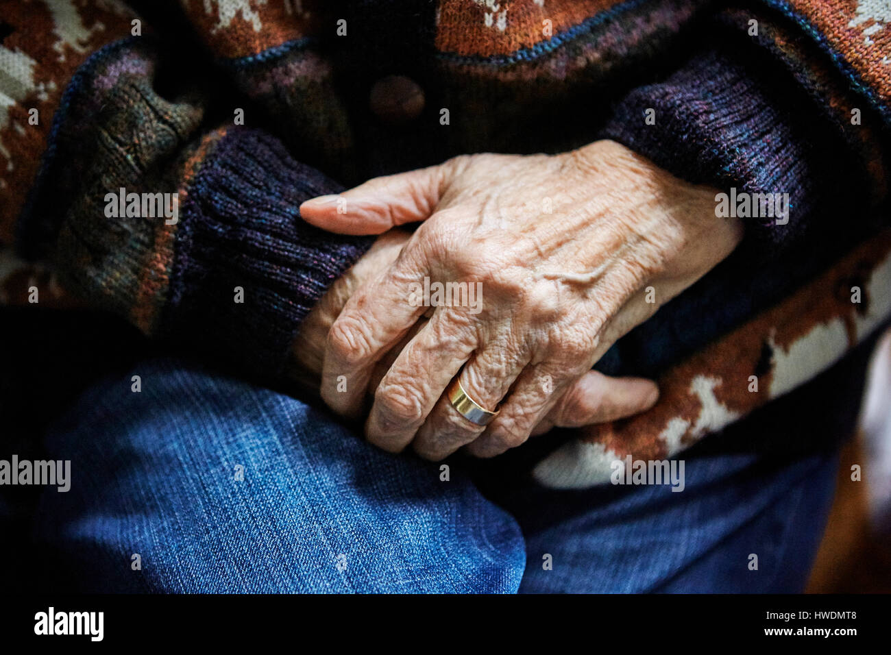 Senior woman sitting in chair, les mains jointes, close-up Banque D'Images