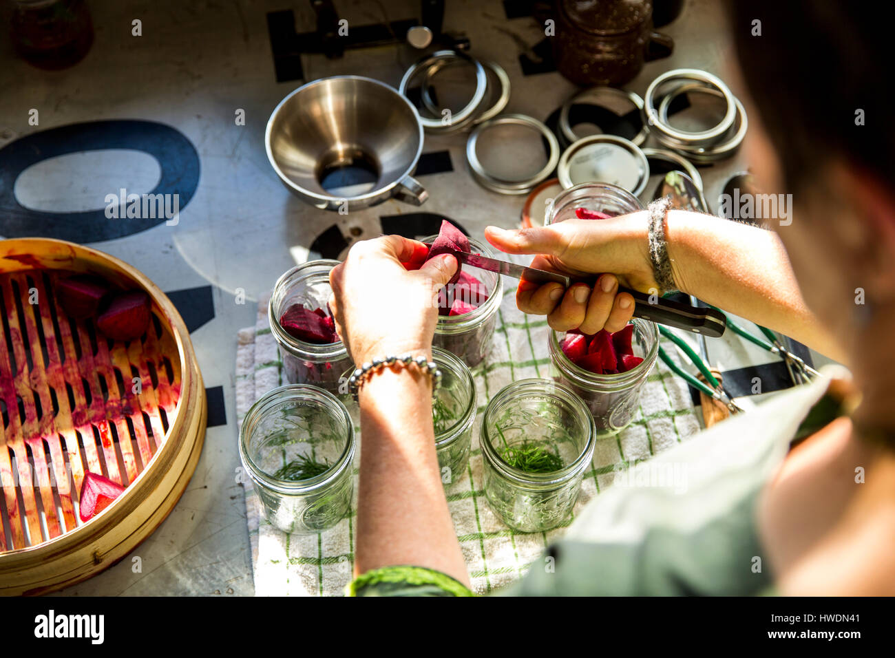 Au cours de l'épaule de woman slicing betteraves en conserve pot dans Cuisine Banque D'Images
