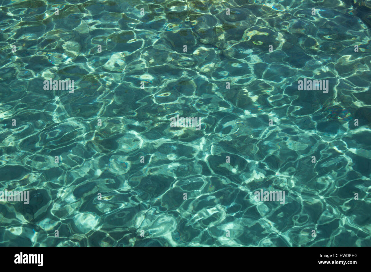 Vue rapprochée de l'eau turquoise cristalline avec le sable du terrain dans la ville de Bodrum. Banque D'Images