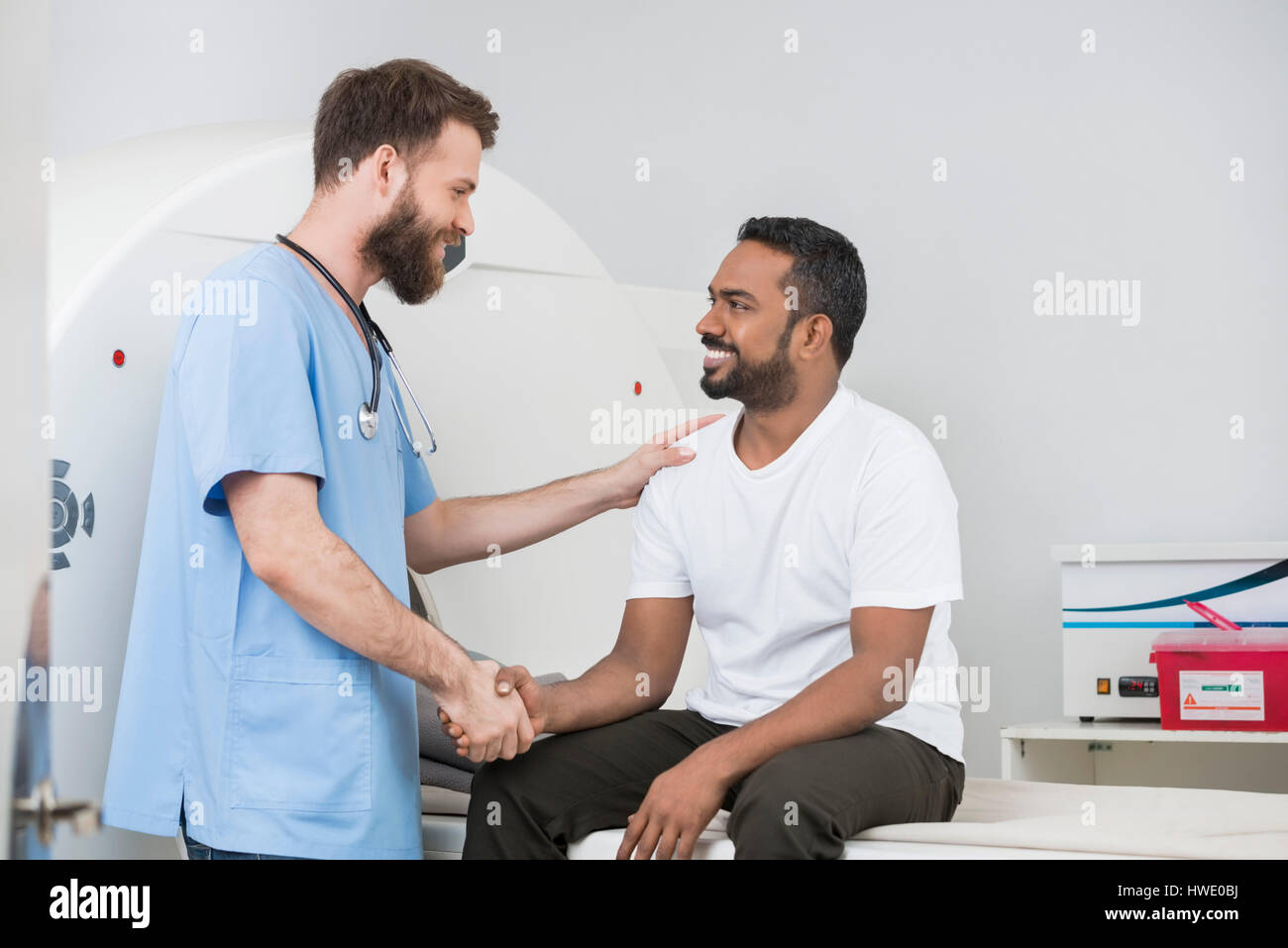 Smiling radiologue et le patient se serrer la main après ct scan Banque D'Images