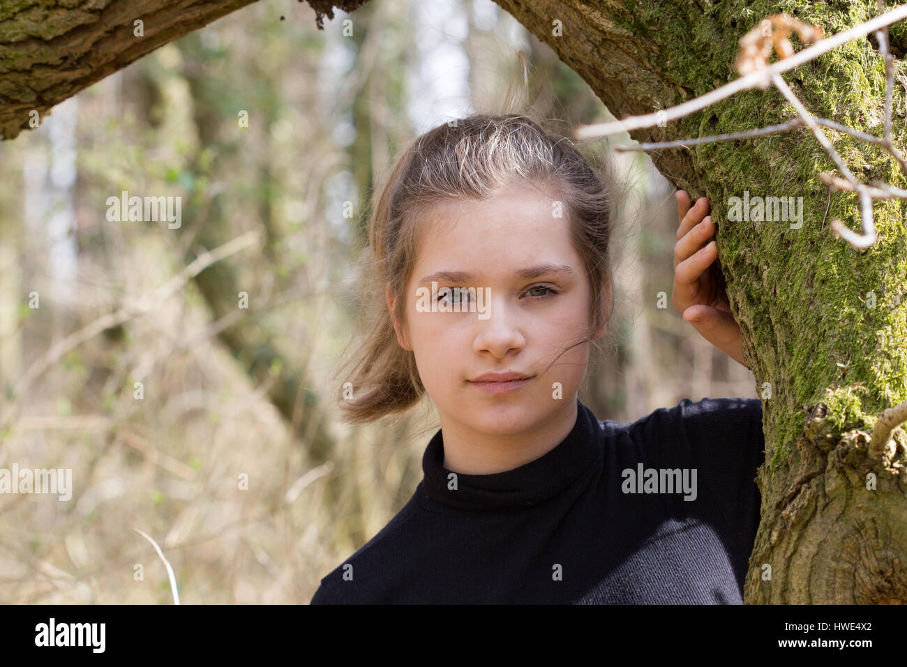 Une jolie fille dans la forêt regarde l'appareil photo Banque D'Images