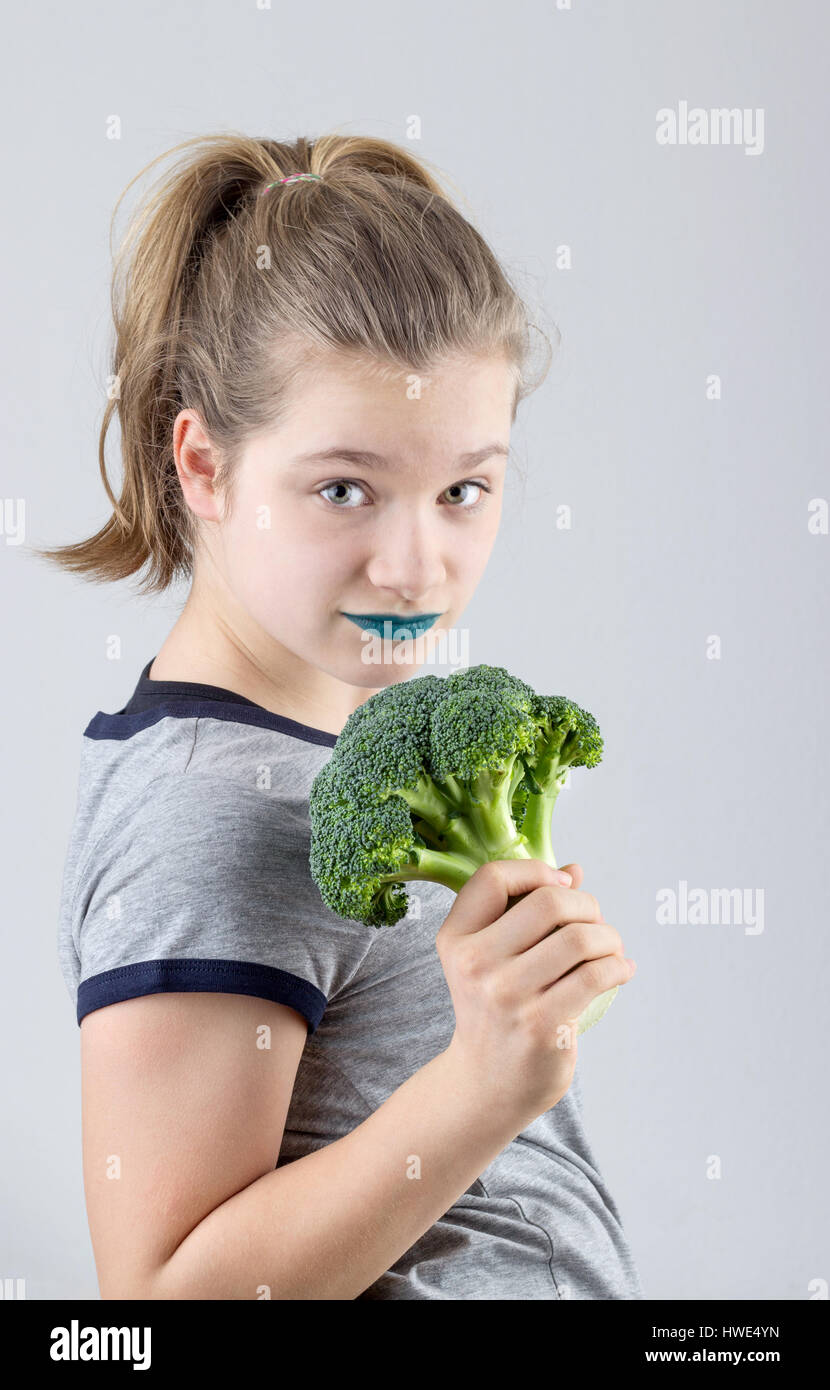 Une jolie fille est une holding broccoli dans sa main Banque D'Images