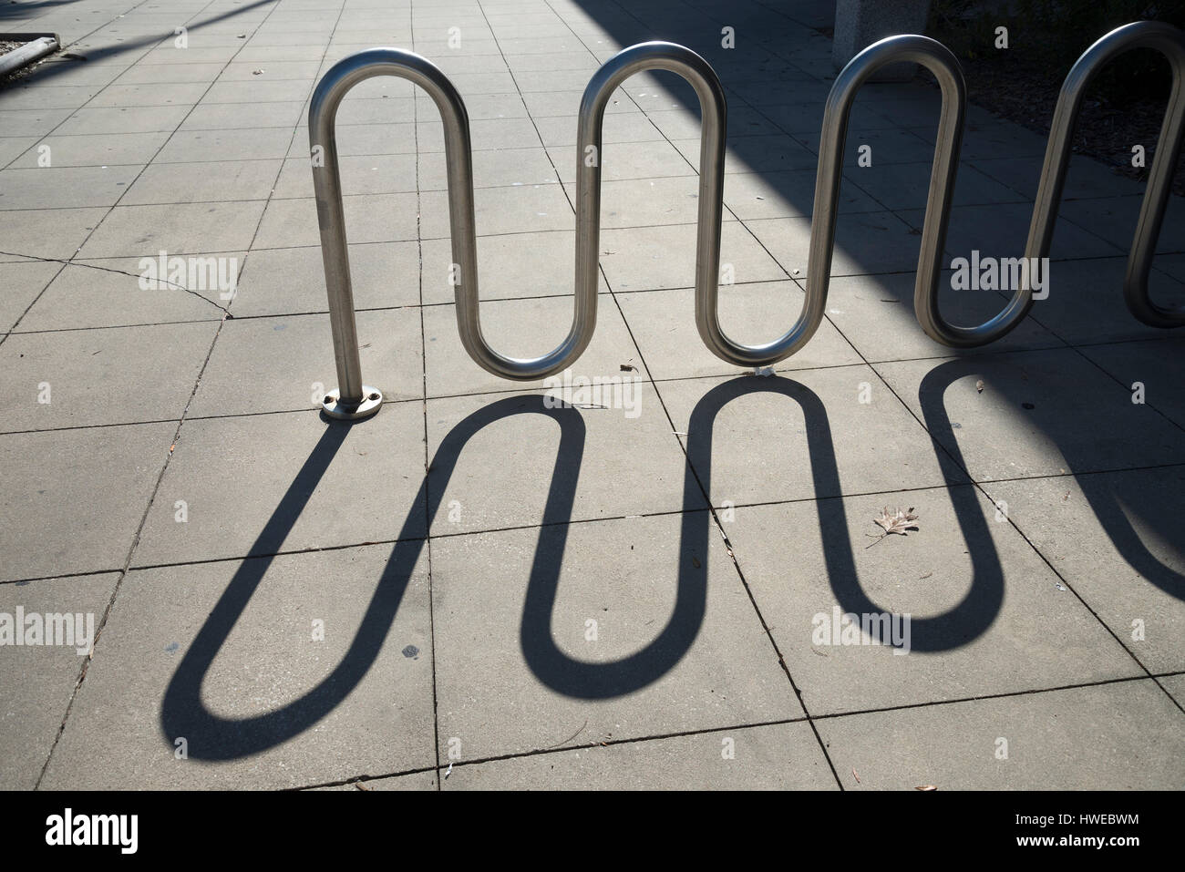 Ombre d'un porte-vélo sur un trottoir. Banque D'Images
