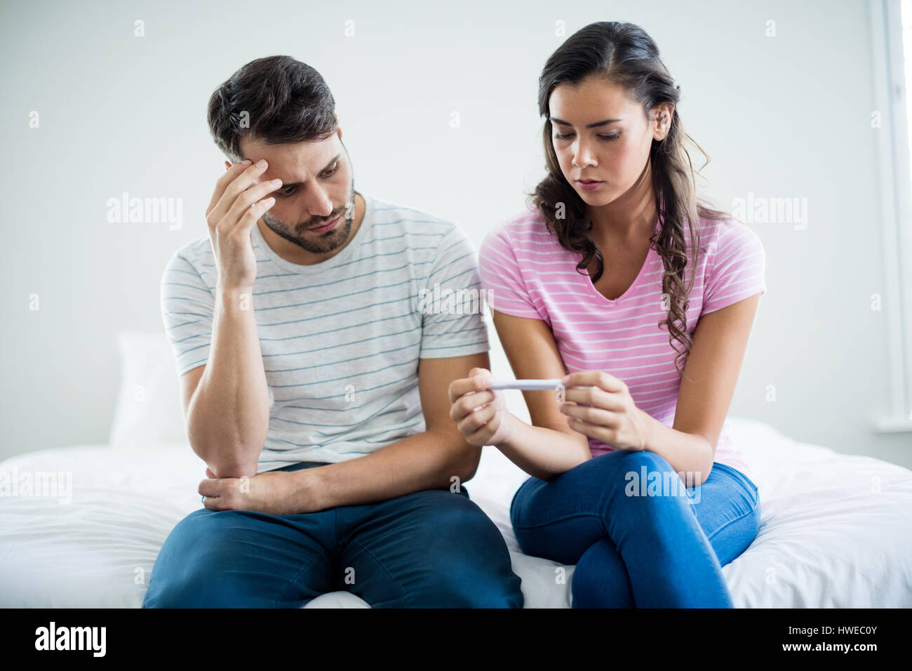 Young couple trouver les résultats d'un test de grossesse dans la chambre à la maison Banque D'Images