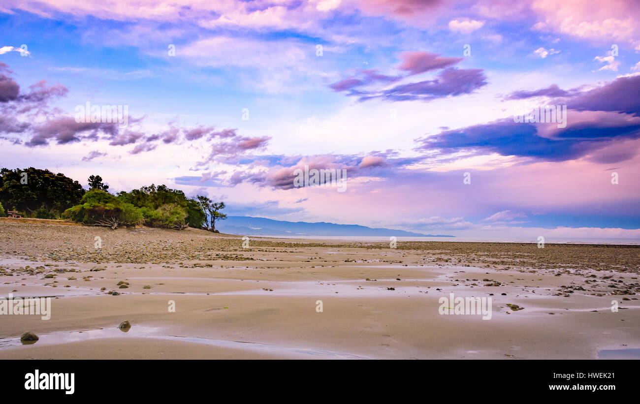De belles formations de nuages pendant le coucher du soleil à plage de kina, Nouvelle-Zélande Banque D'Images