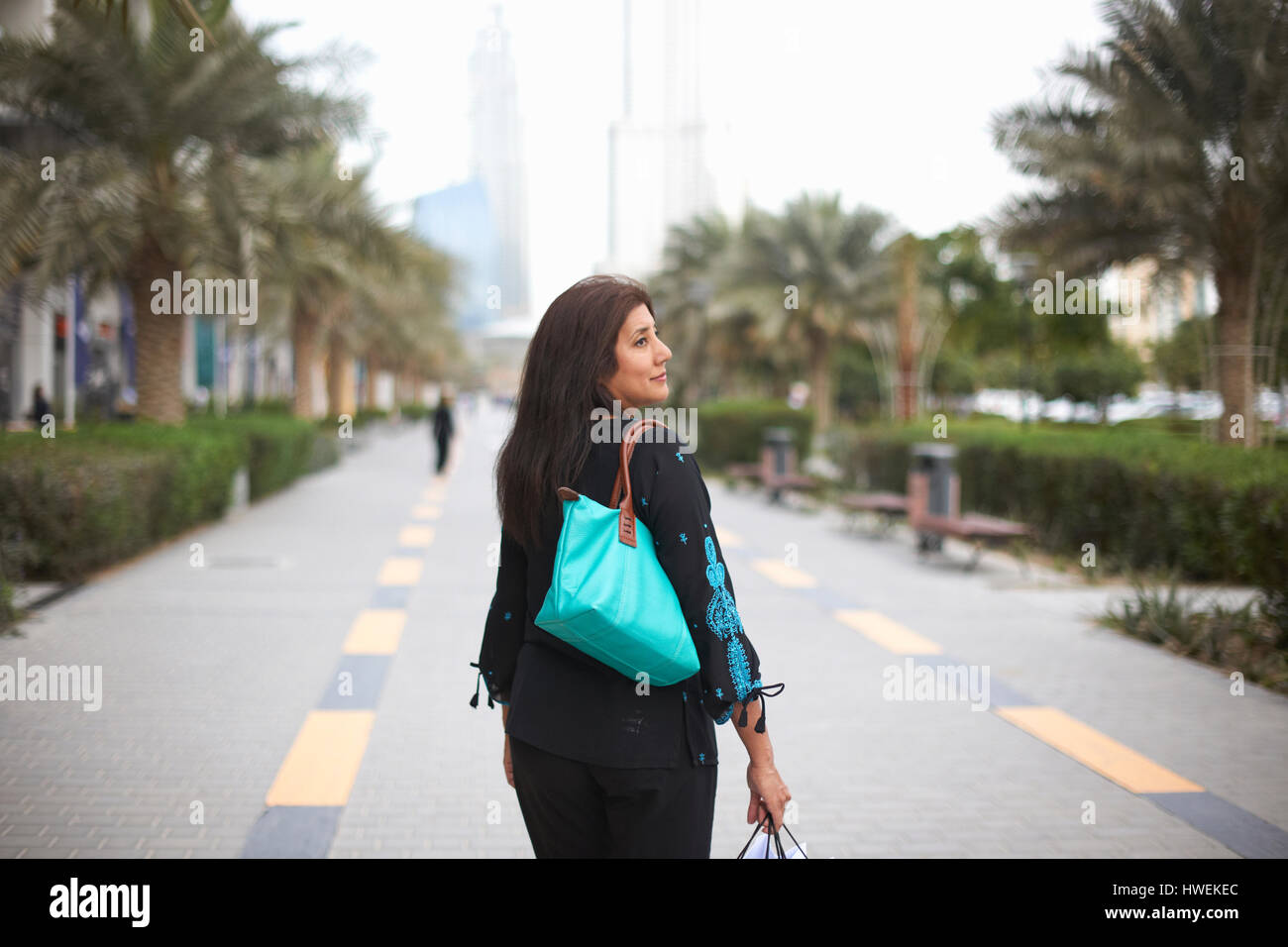 Vue arrière du mature female shopper carrying shopping bags, Dubaï, Émirats Arabes Unis Banque D'Images
