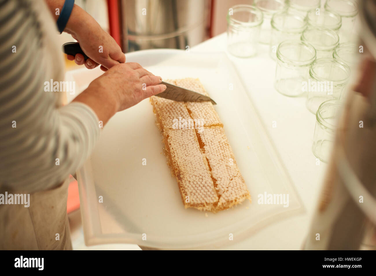 Cropped shot de découpage en nid d'apiculteur femme cuisine Banque D'Images