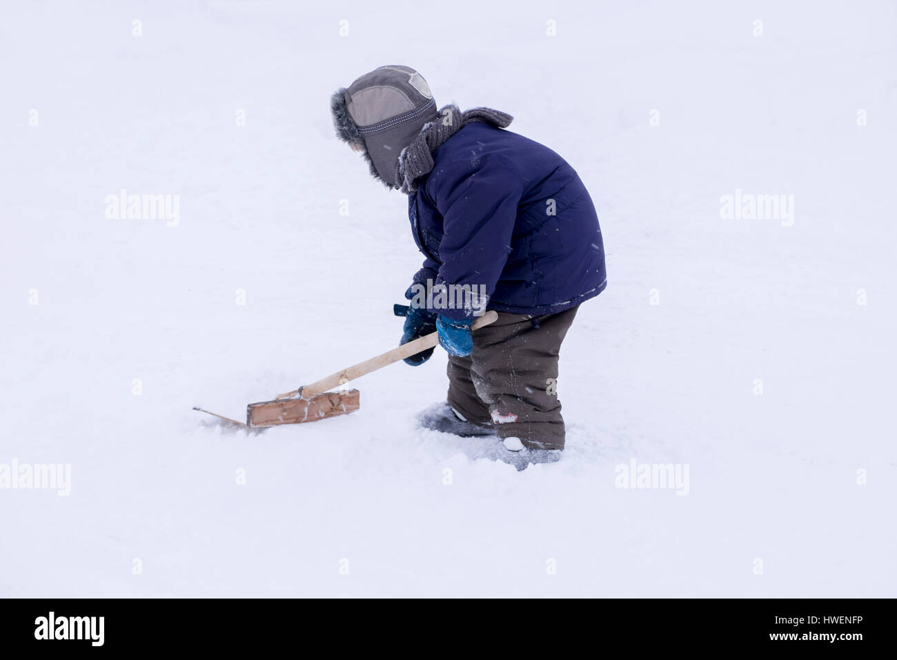 Bébé garçon pelleter la neige Banque D'Images
