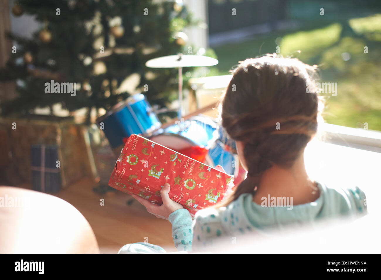 Plus d'épaule de fille assise sur le plancher du salon opening christmas gift Banque D'Images