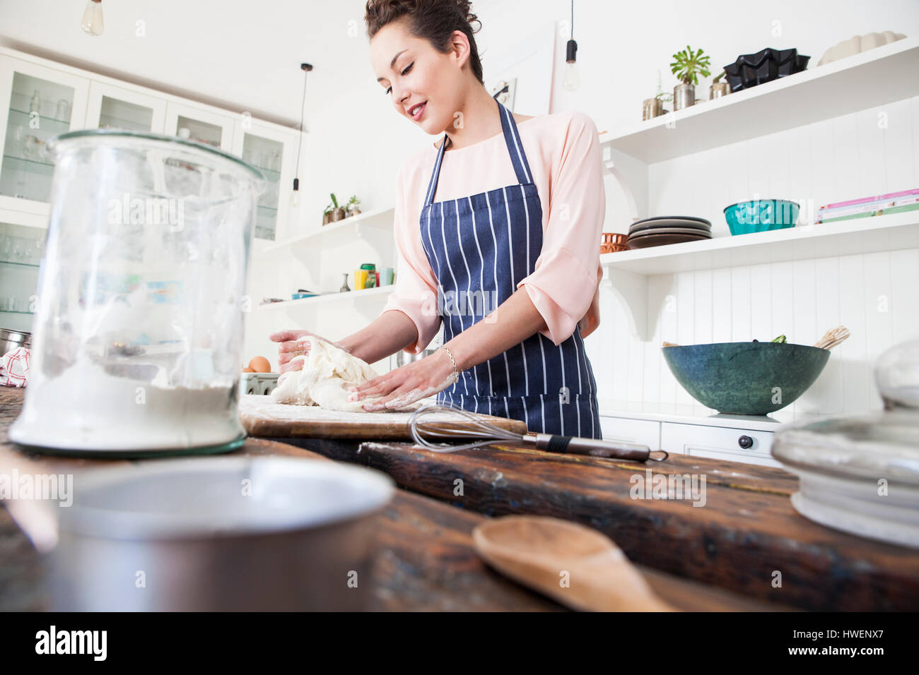 Jeune femme façonner la pâte à compteur de cuisine Banque D'Images