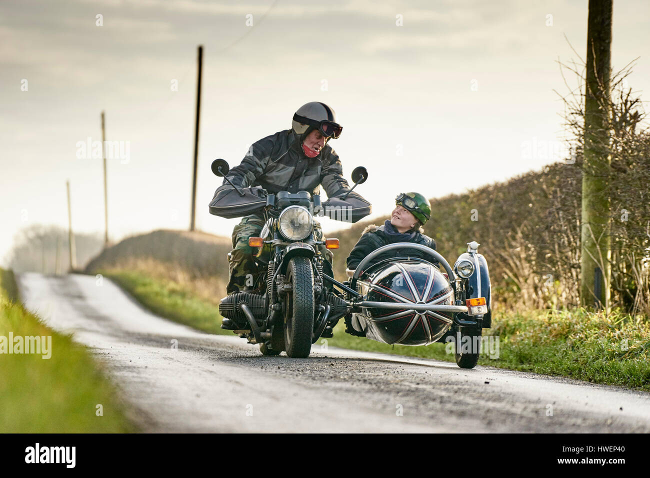 Man et petit-fils et d'un side-car moto équitation le long chemin rural Banque D'Images