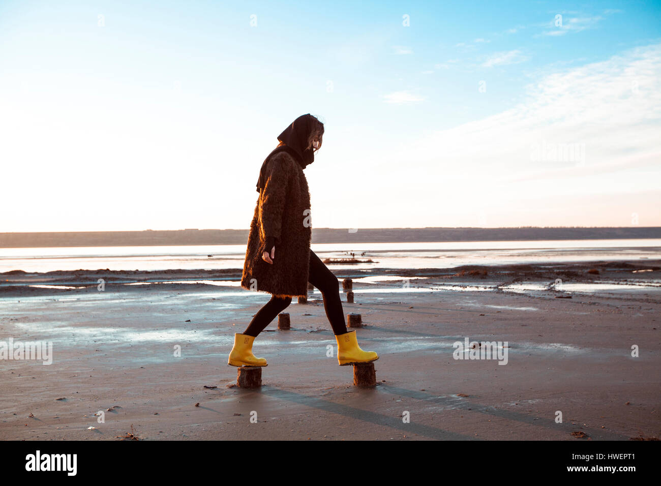 Femme en équilibre sur les souches en bois on beach Banque D'Images