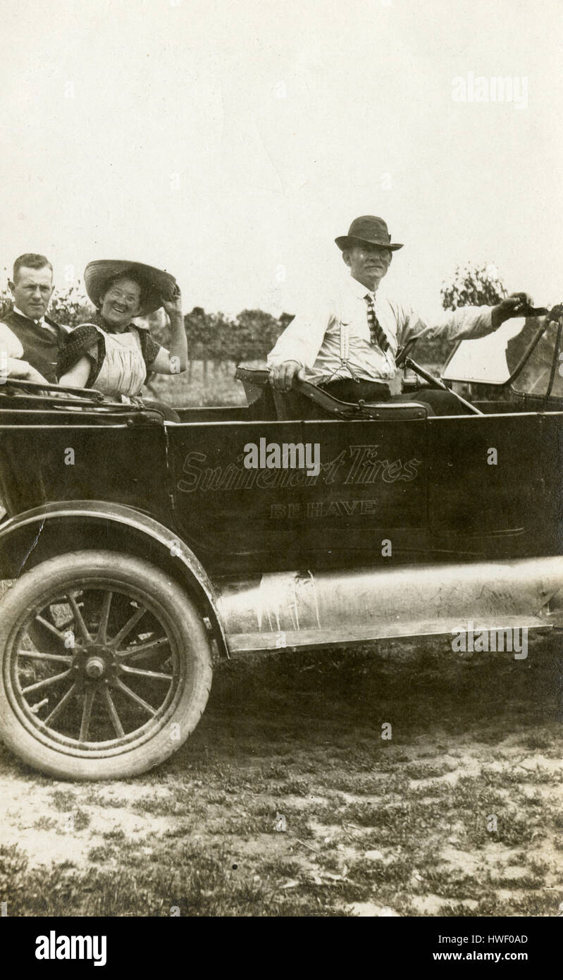 Meubles anciens c1915 photo, deux hommes et une femme dans un c1915 touring Ford, avec de la publicité pour des pneus Swinehart sur le côté. Lieu : New York, USA. Voir Alamy HWF0BK pour une autre vue de cette image. SOURCE : tirage photographique original. Banque D'Images