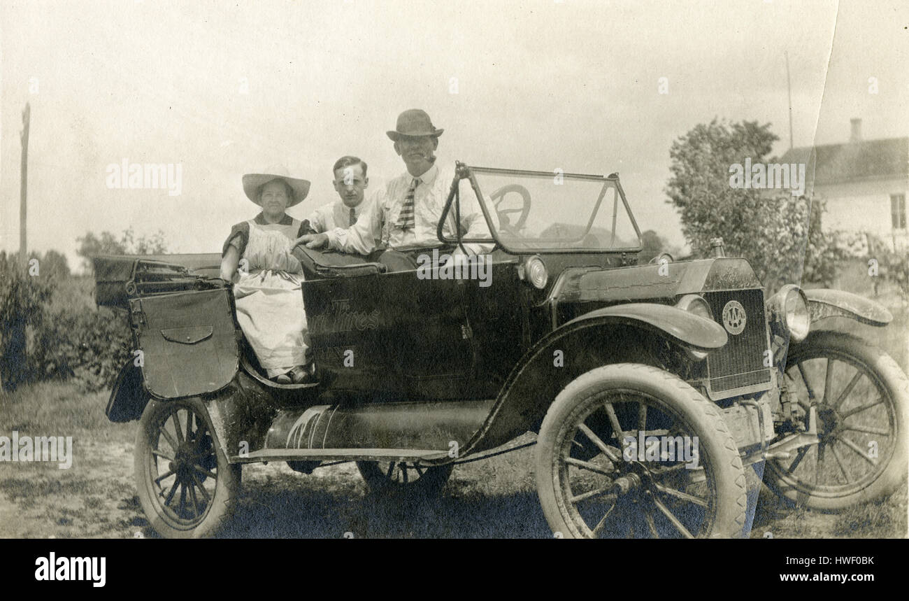 Meubles anciens c1915 photo, deux hommes et une femme dans un c1915 touring Ford, avec de la publicité pour des pneus Swinehart sur le côté. La calandre d'un insigne pour AAA Club de New York. Voir Alamy0HWF annonce pour une autre vue de cette image. SOURCE : tirage photographique original. Banque D'Images