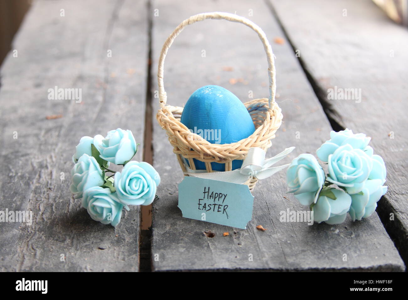 Joyeuses Pâques. Oeuf de Pâques dans un panier sur un arrière-plan vintage et de fleurs de printemps.. Banque D'Images