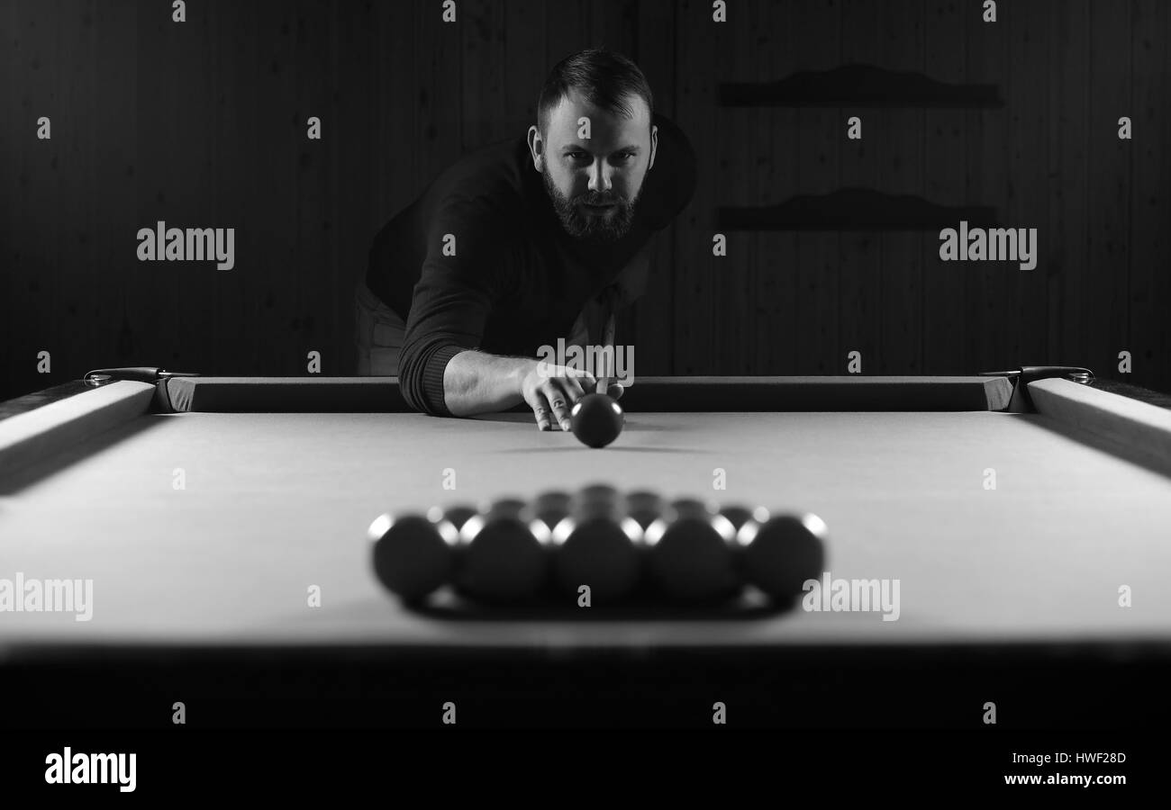 Photo monochrome jeune homme jouant au billard Banque D'Images