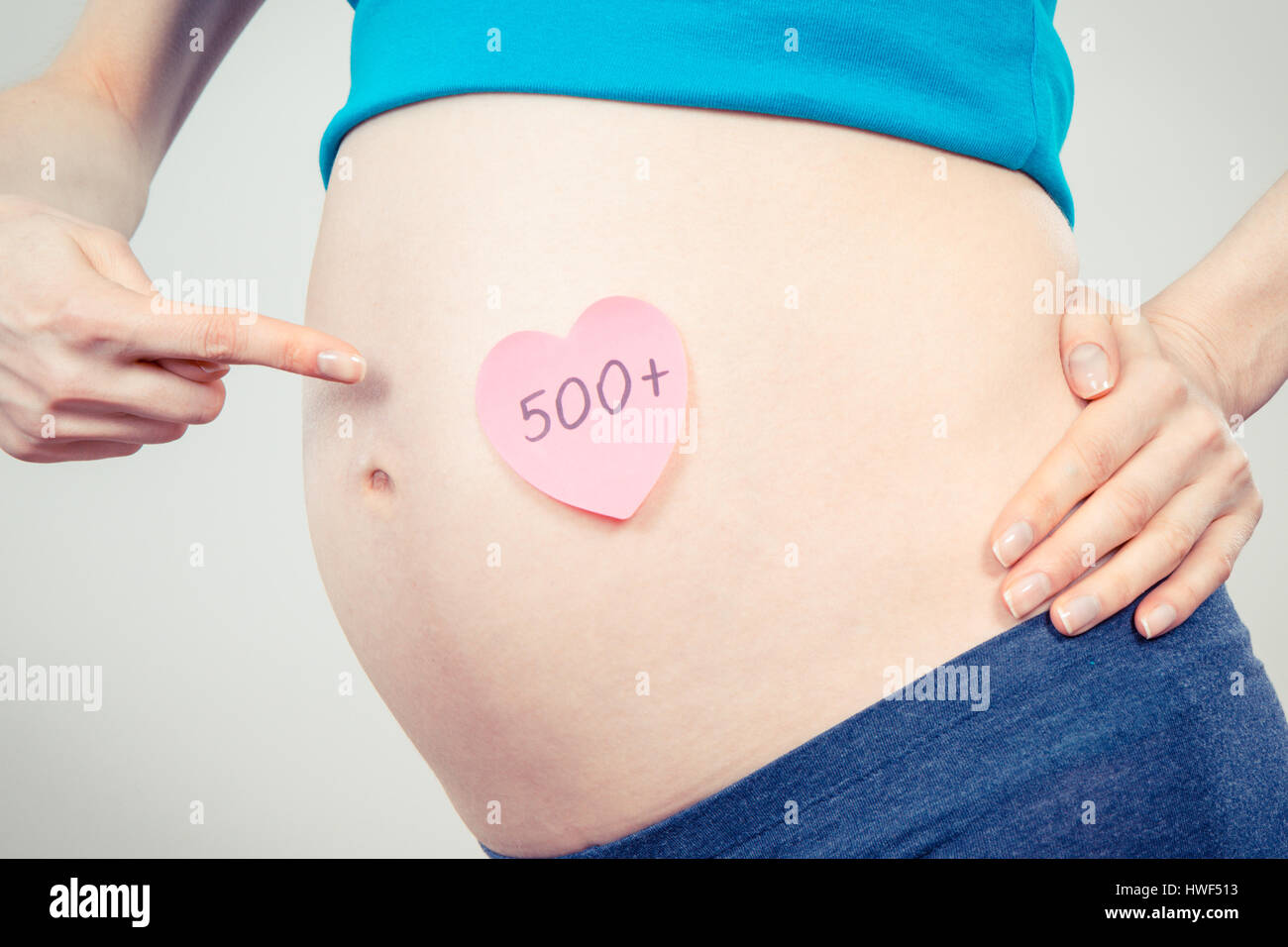 Femme enceinte montrant feuille de papier avec l'inscription 500 +, programme social et politique en Pologne Banque D'Images