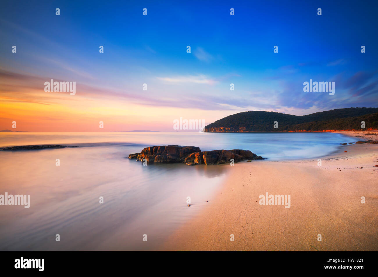 Coucher de soleil plage de la baie de Cala violina en Maremme, Toscane. Destination de voyage en mer Méditerranée. L'Italie, l'Europe. Longue Exposition. Banque D'Images