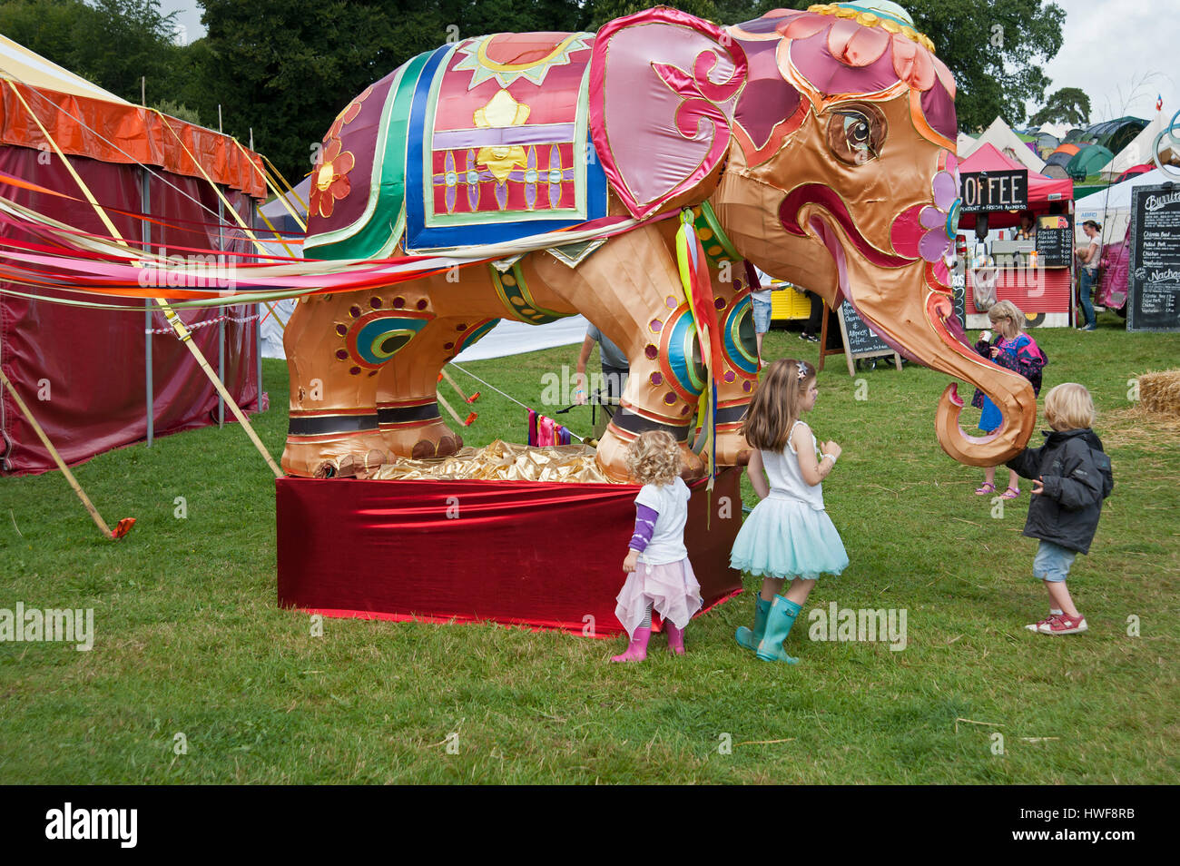 Enfants Jouant Devant Un Grand Elephant Couvert De Soie Colores De Tentes Et D Aliments Pour Bebe Cale Au Port Eliot Cornwall Festival Photo Stock Alamy