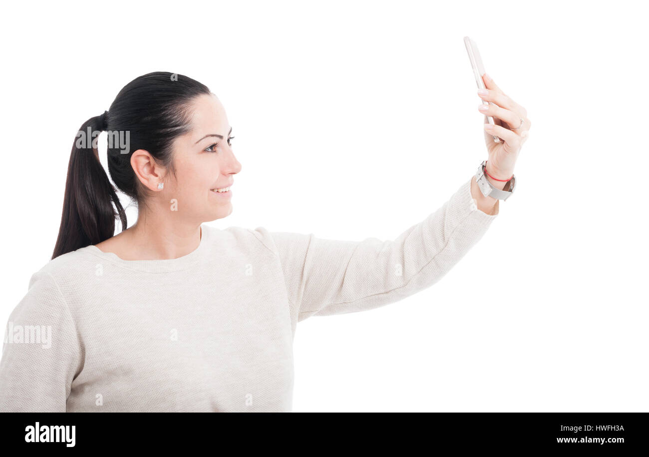 Belle femme prendre un autoportrait avec son portable et souriant sur fond blanc Banque D'Images
