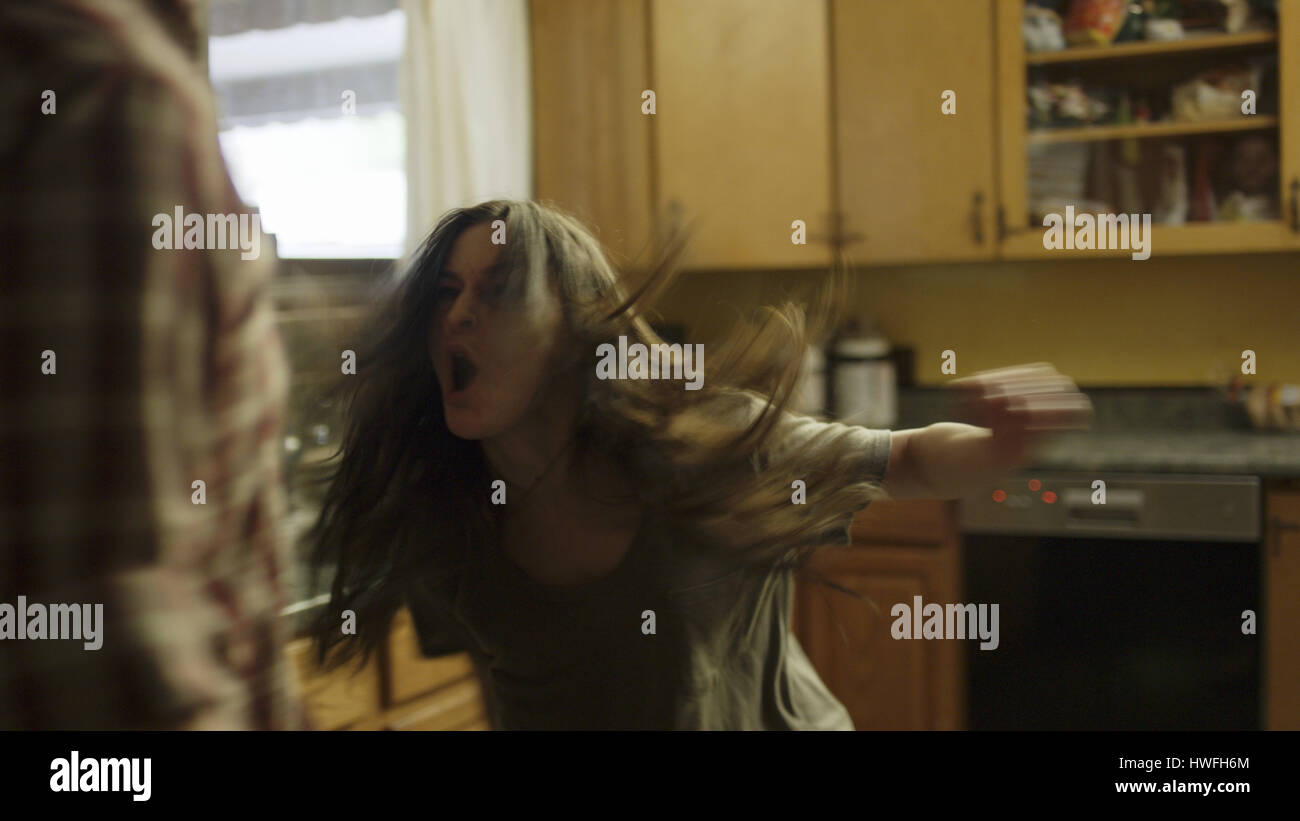 Selective focus blurred view of angry girlfriend criant à petit ami dans la cuisine Banque D'Images