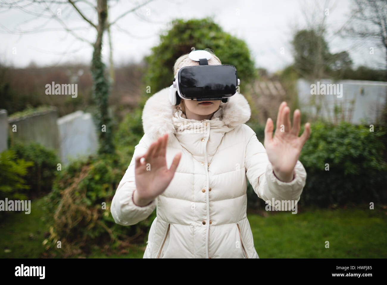 Manteau femme en fureur à l'aide de casque de réalité virtuelle à l'extérieur Banque D'Images Manteau femme en fureur à l'aide de casque de réalité virtuelle à l'extérieur Banque D'Images